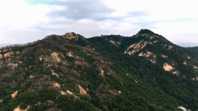 구름 낀 하늘 아래 푸른 산