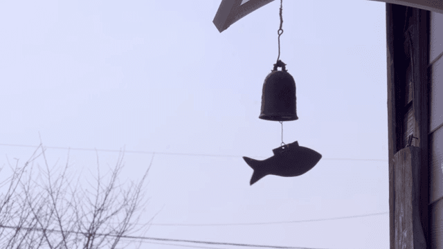 Traditional shaped bells swinging under the roof