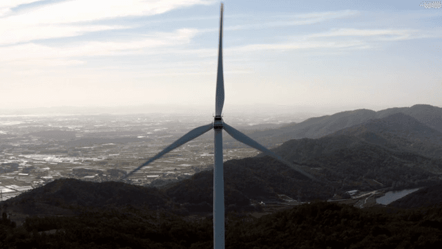 마을이 보이는 산악 지역의 풍력 터빈