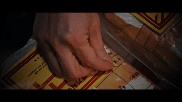 포장된 폐기처분 물질에 찢어진 스티커를 붙이는 손