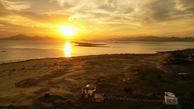 Sunset over a calm sea with distant mountains