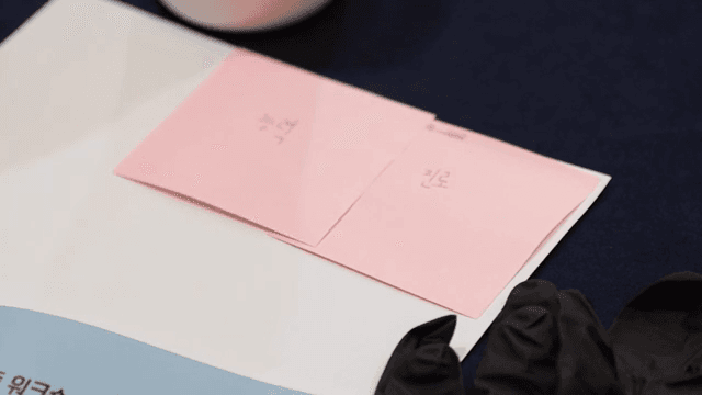 분홍색 메모지에 글을 쓰는 손