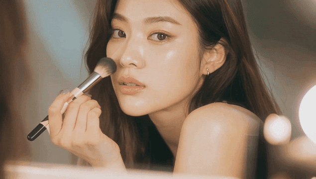 브러시로 메이크업하는 여성