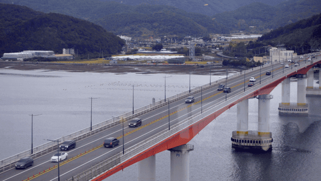 강 위의 다리를 달리는 자동차들