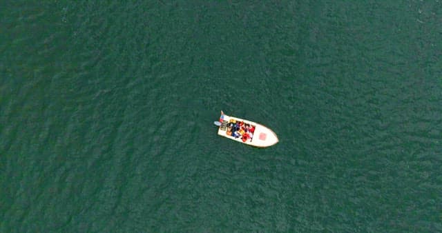 Boat with people on a vast ocean