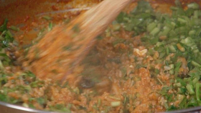 Stirring the fried rice with water parsley well in the pan