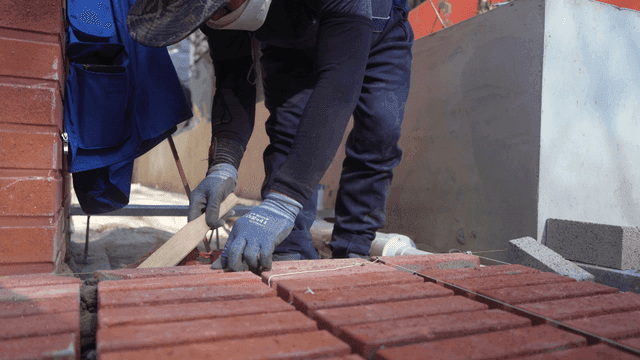 Worker cleaning bricks at a construction site
