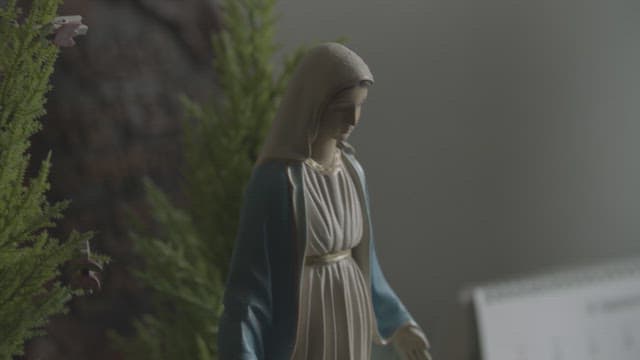 성모상을 신중히 다루는 장갑 낀 손