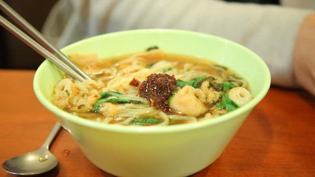 Bowl of udon with spicy sauce and fish cake