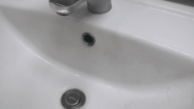 더러운 흰색 욕실 세면대와 수도꼭지