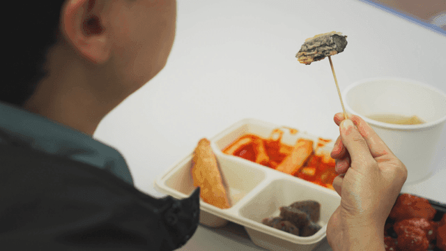 Person eating deep-fried gimari on a skewer