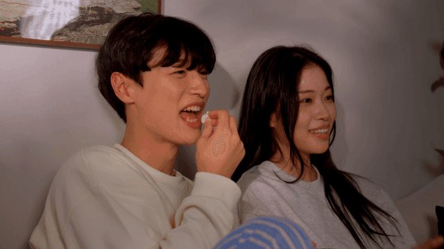 Couple watching funny movie at home with popcorn