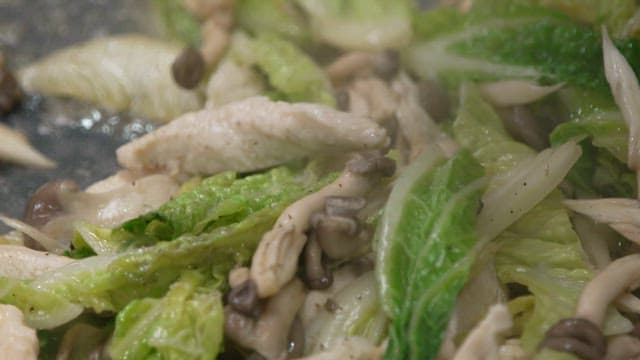 Mushrooms and cabbage stir-fried in a hot oiled frying pan