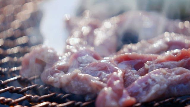 바베큐 그릴에서 고기를 굽는 장면