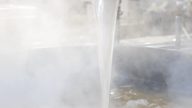 Steaming broth being poured into a pot