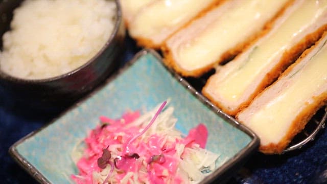치즈 돈가스와 밥, 샐러드가 담긴 접시