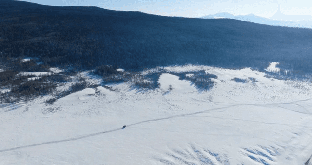 Car traveling through a snowy landscape