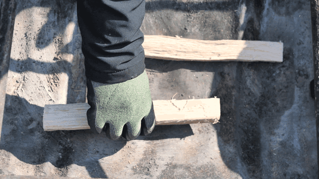 Hand stacking pieces of wood