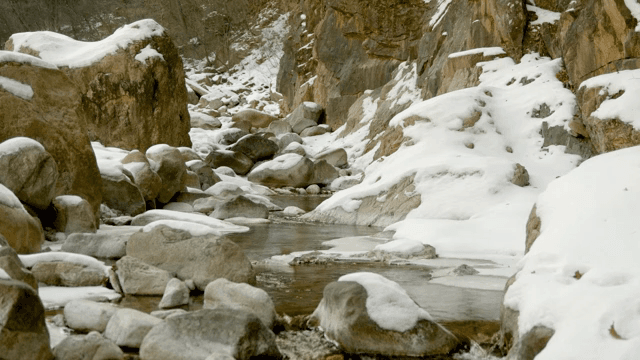 Snow-covered rocks and a flowing stream