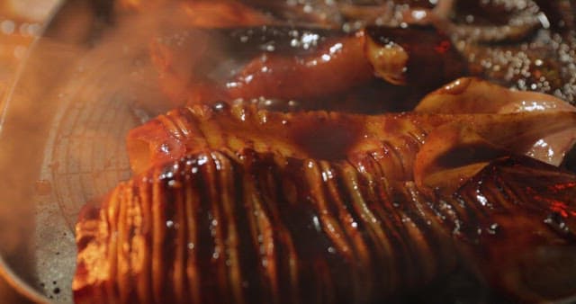 Sizzling squid being cooked on a grill