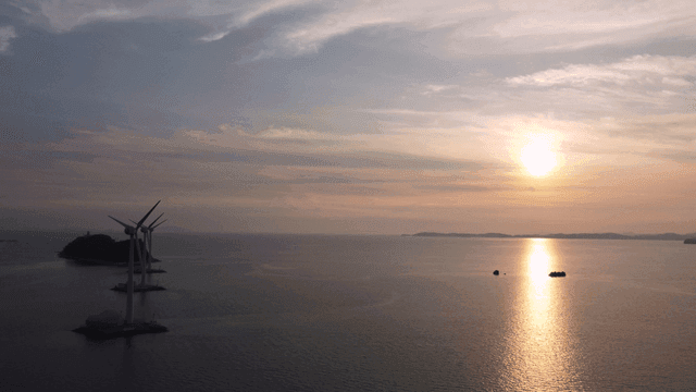Wind turbines on sea at sunrise