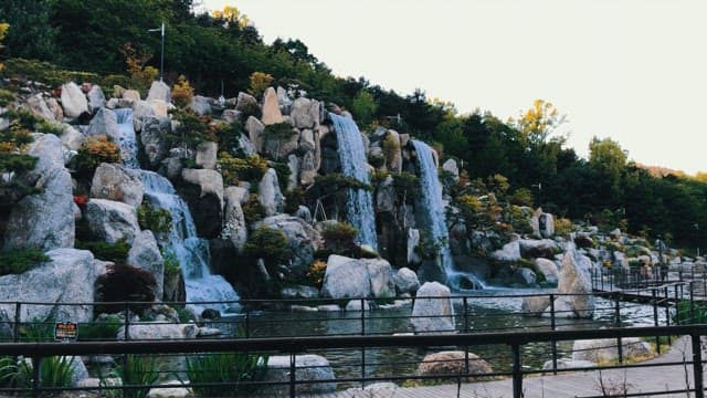 낮에 풍경 정원을 흐르는 폭포