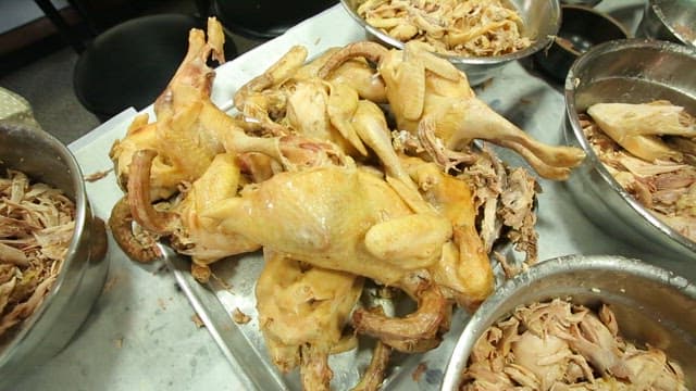 거대한 닭고기를 손질하고 있는 여러 사람들