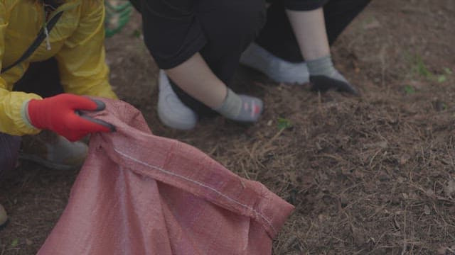 빨간 포대자루에 흙을 주워 담는 사람들