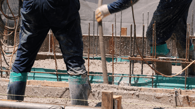 Construction worker using vibrator on concrete