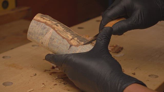 Hands carving wood with precision