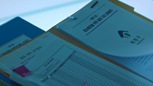 Person Examining Documents in File in Office