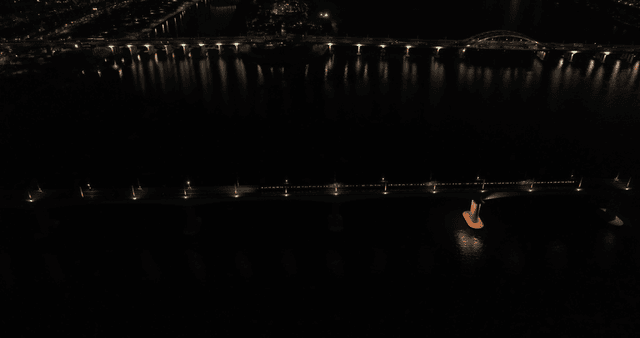 Night view of subway crossing bridge over river