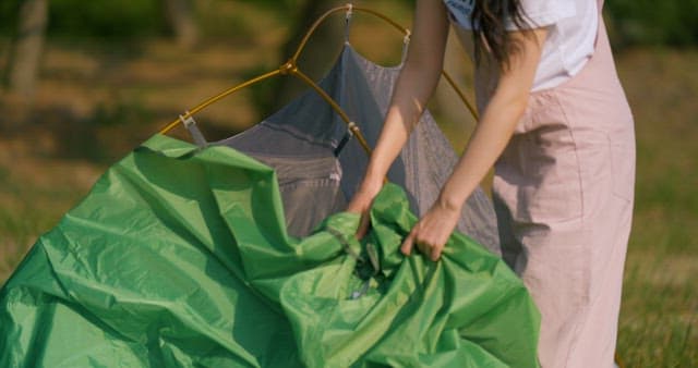 Green Tarp Draped Over Tent Poles