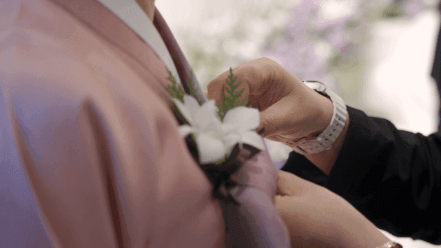 분홍색 한복에 꽃을 다는 모습