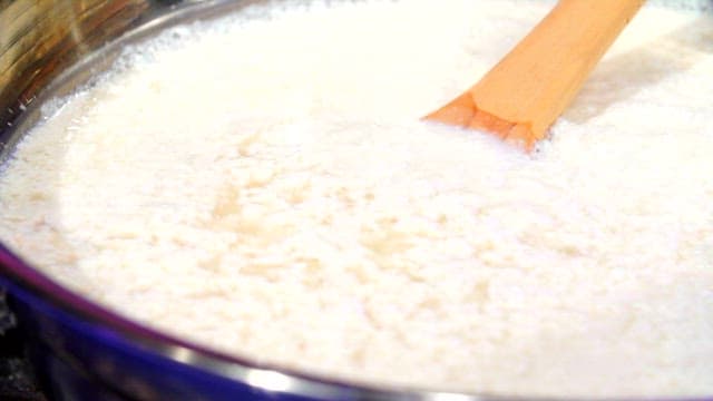 Stirring bean water in a container with a paddle