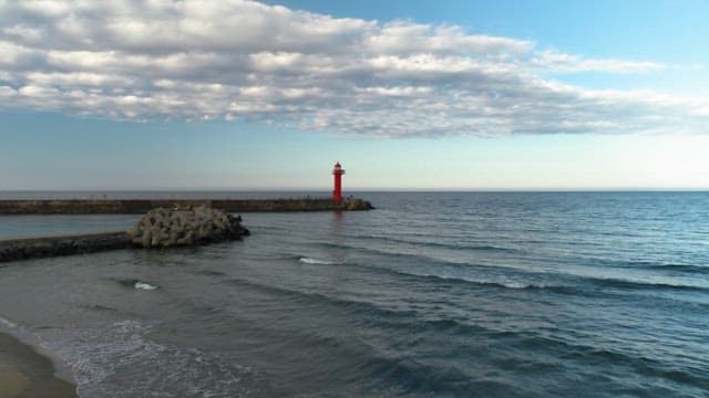 Serene Seascape with Red Lighthouse at Dusk