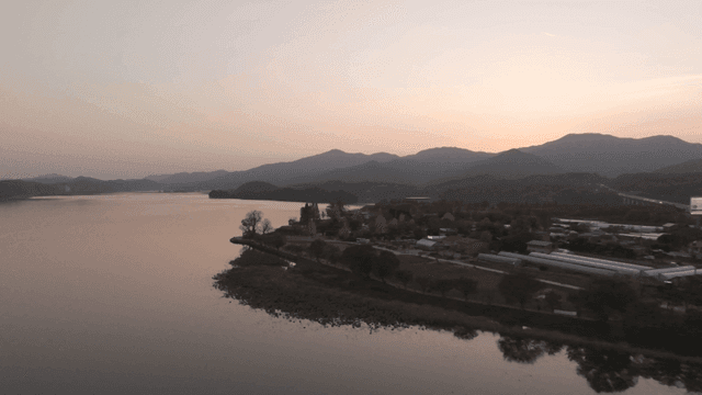 Quiet river where sun sets over mountains