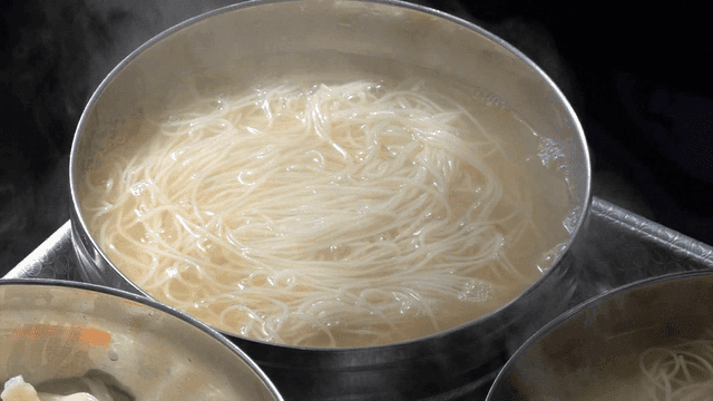 Hot clear broth poured over banquet noodles