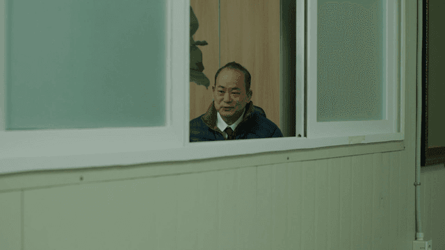 Man smiling and talking beyond window