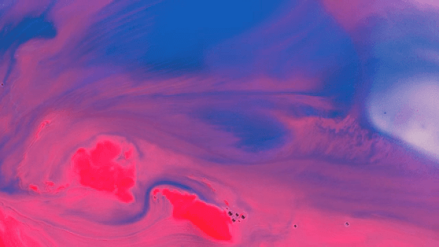 Abstract pattern of blue and pink liquids mixing together