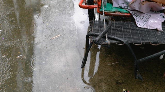 Alleyway on a rainy day with puddles and a cart