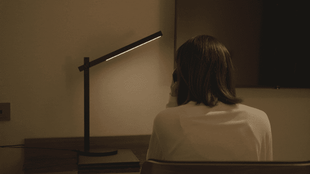 책상 앞에서 전화하는 여성의 뒷모습