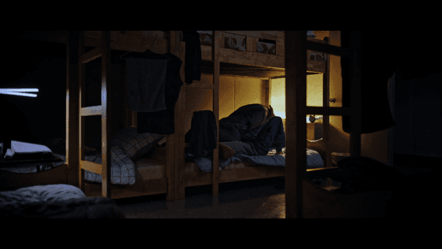 Sleeping restlessly under a bunk bed in dark room