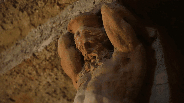 Ancient stone sculpture in a dimly lit cave