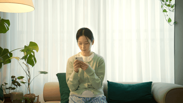 Woman sitting on a sofa using a smartphone