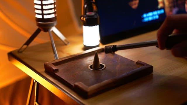 나무 받침대에 콘 모양의 인센스 향을 피우는 장면