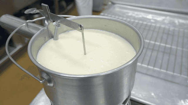 Milk being heated in a metal pot