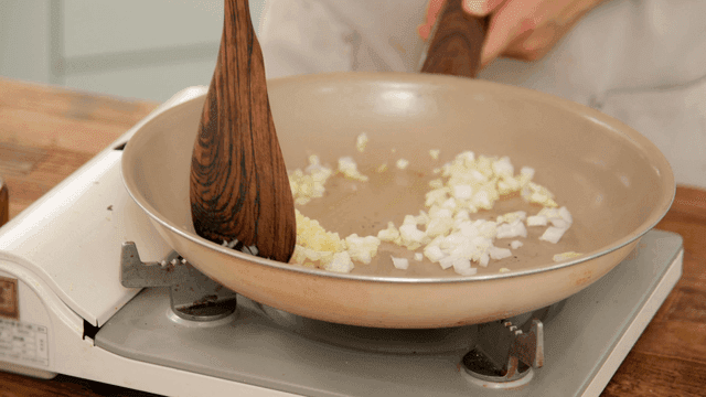 Chopped onions and garlic sautéed in frying pan