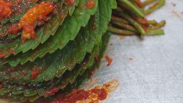 Making kimchi by adding chili pepper seasoning to perilla leaf kimchi