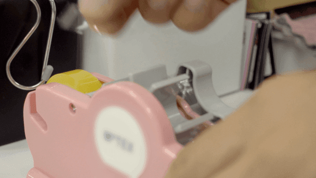 분홍색 테이프 디스펜서를 조작하는 손